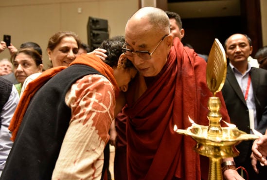 达赖喇嘛尊者在发表演讲前拥抱卫德亚尔克组织的成员  2018年8月12日  照片/Tenzin phende/DIIR