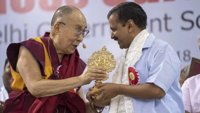 2018年7月2日，达赖喇嘛尊者在新德里的蒂亚格拉杰体育场举行的德里政府学校快乐课程启动仪式上向德里首席部长阿文德·凯杰里瓦尔赠送吉祥徽章 照片/Tenzin Choejor/OHHDL