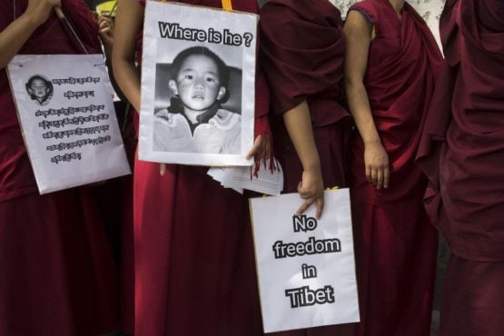 流亡印度的藏人僧尼在抗议游行中举着标语牌，要求中共释放第十一世班禅喇嘛根敦·确吉尼玛   照片/2017 AP Photo / Ashwini Bhatia
