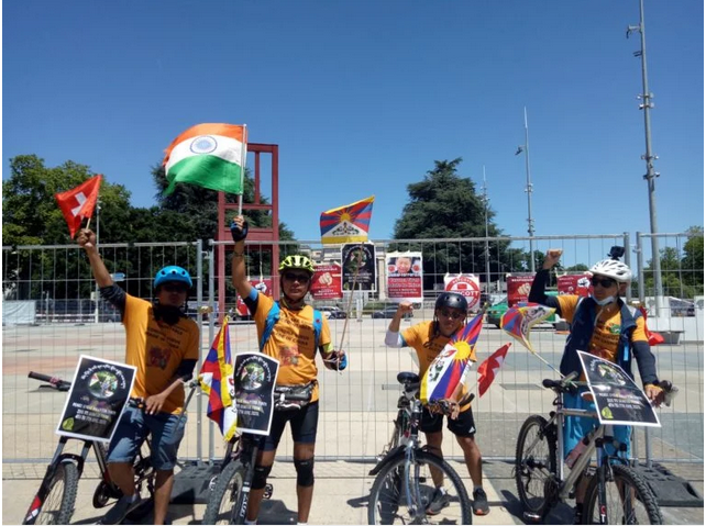 展开单车巡游活动的藏人手持西藏，瑞士和印度国旗在日内瓦联合国办事处前举行游行活动   照片/驻日内瓦办事处提供